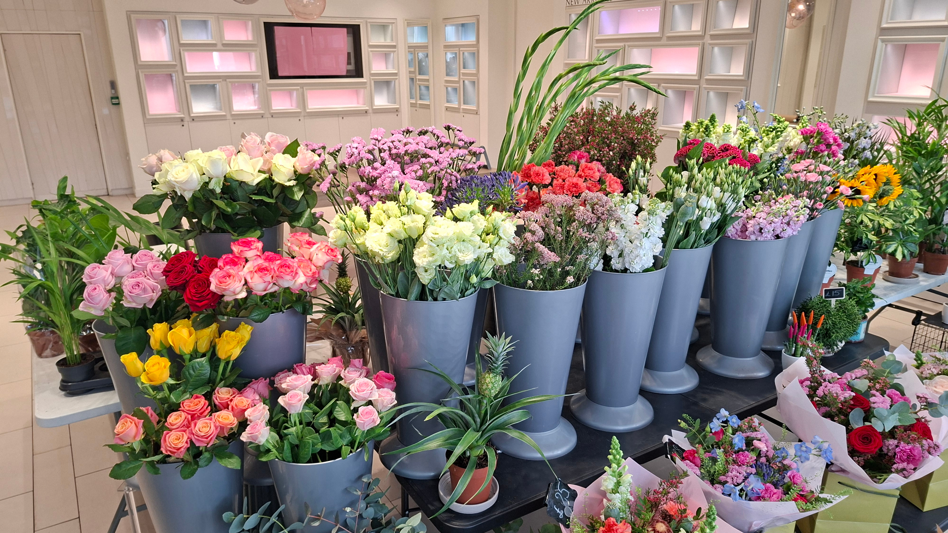 Buckets of fresh roses, lisianthus, stocks and agapanthus inside our Sutton flower shop