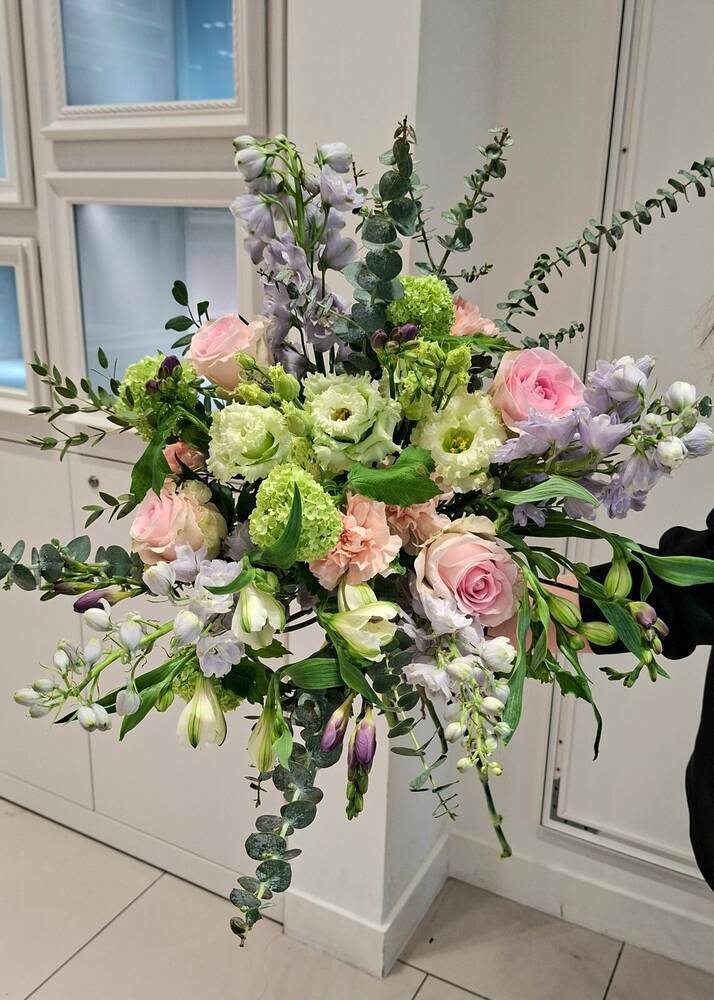 Hand-tied Feel Drop Co bouquet with pink roses, lisianthus, delphinium and eucalyptus
